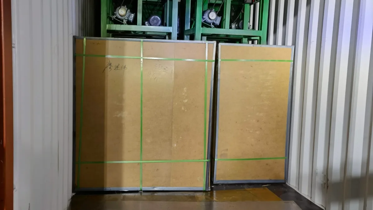 Green steel racks and cartons at the back of a container