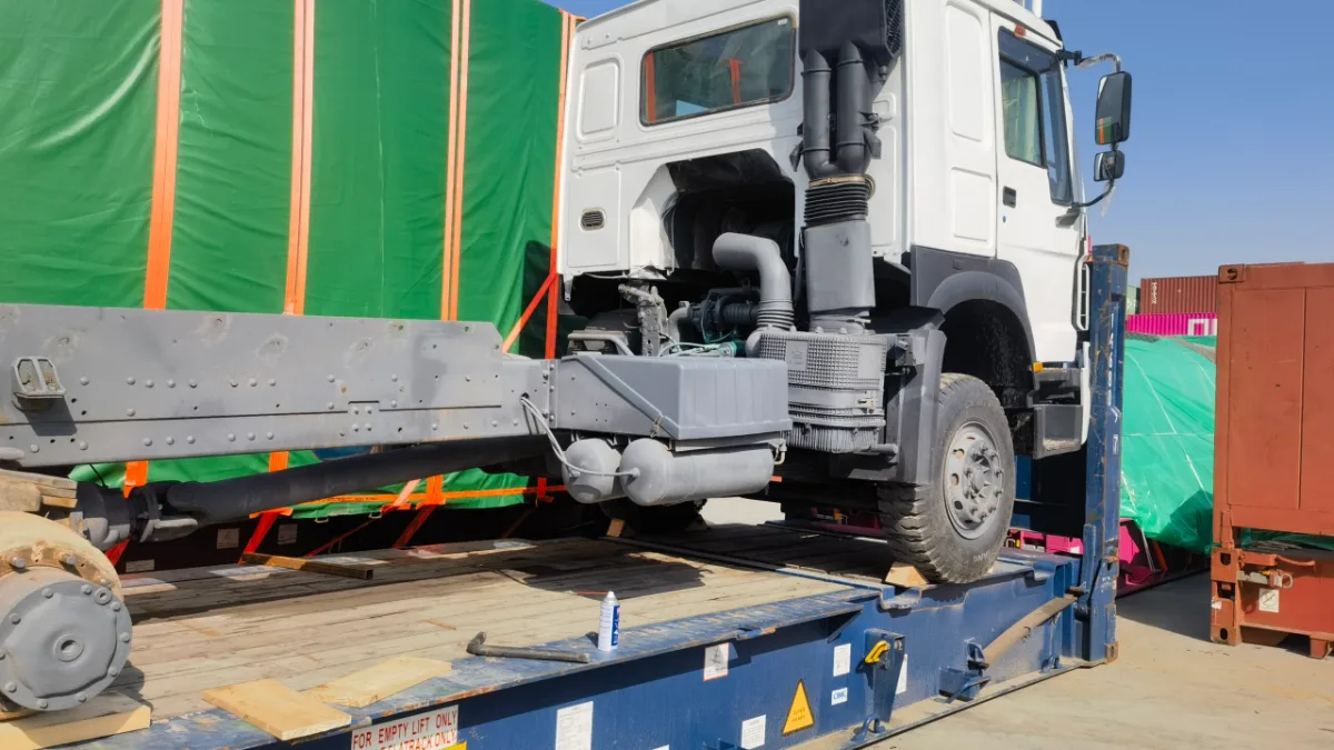 Heavy truck secured on a flat rack container at the port