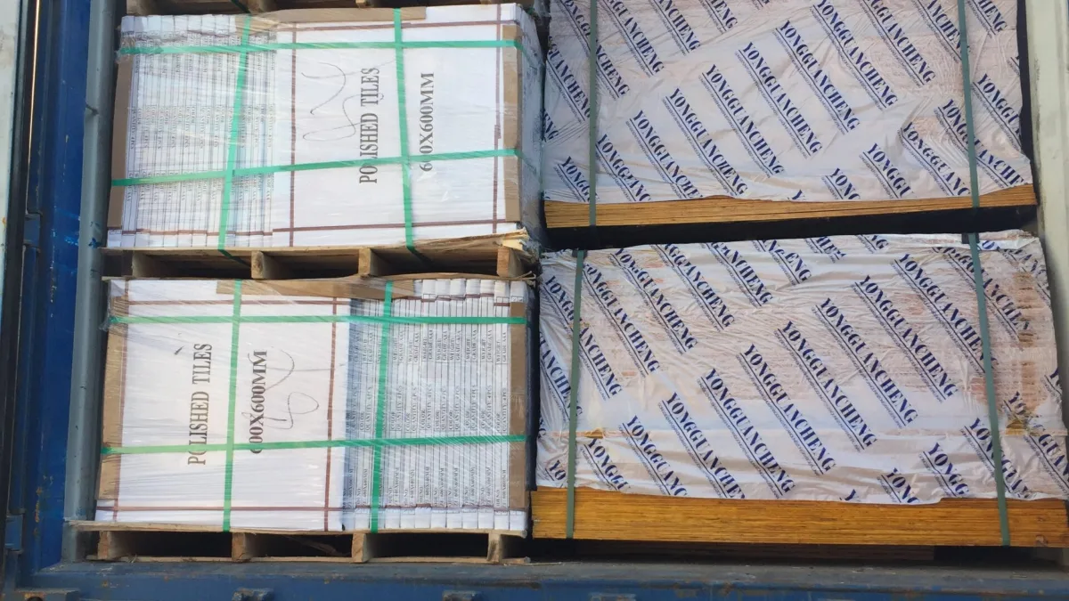 Palletized building panels and wood-grain profiles loaded in a container on a truck