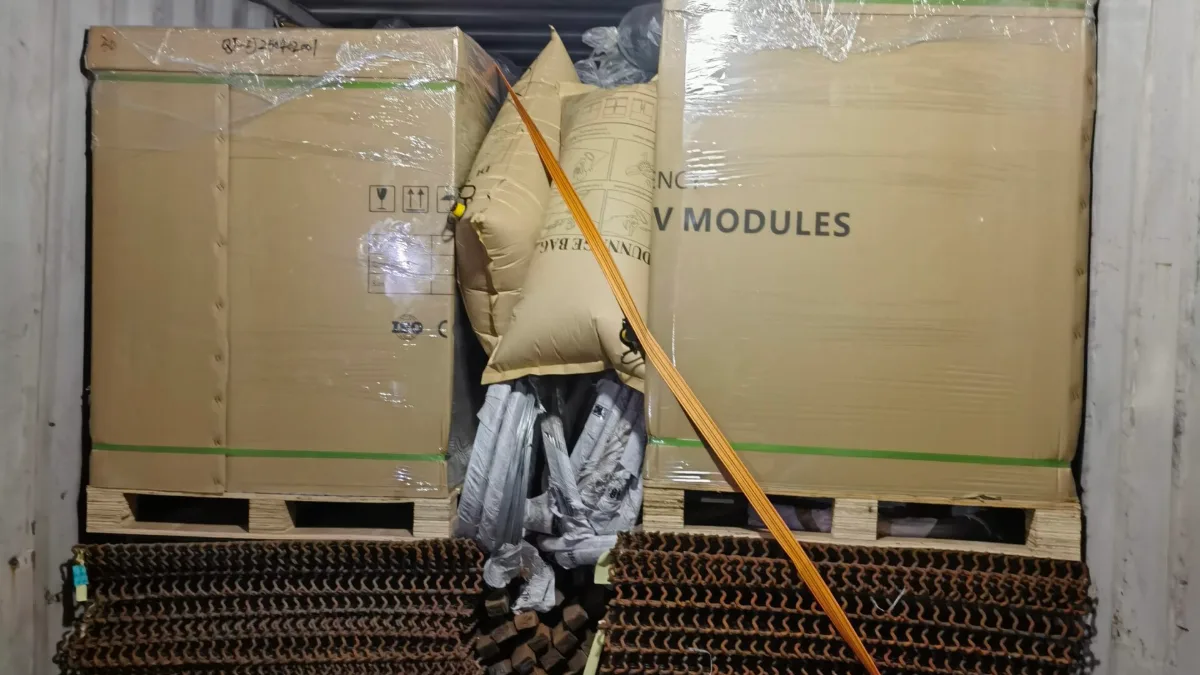 Solar panel pallets secured with straps and air bags in a container