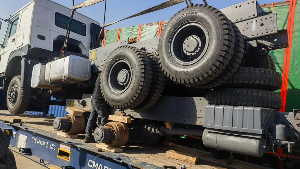 Truck lashed on a flat rack container for shipment