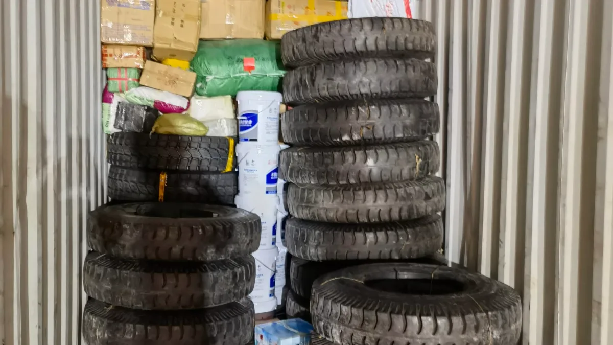 Truck tyres stacked with cartons inside a container