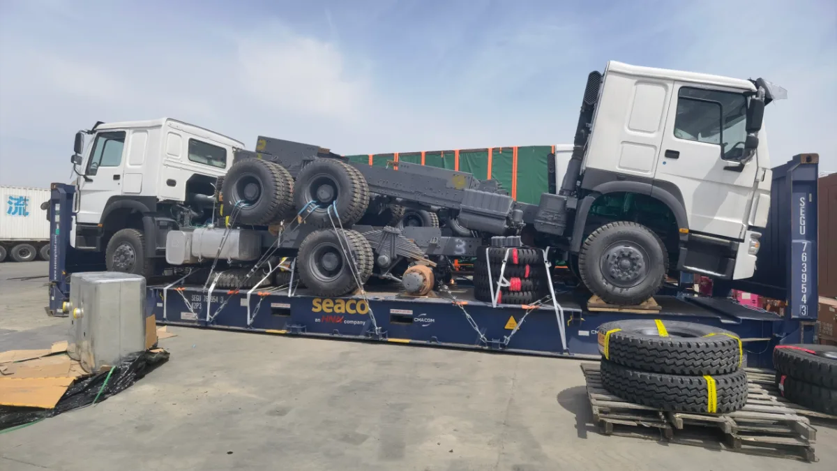 Trucks on flat rack containers ready for shipping