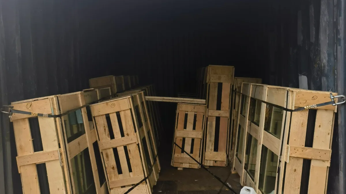 Wooden crates with window frames secured in a container